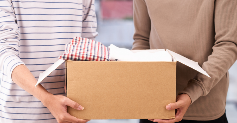 Two people holding a cardboard box.